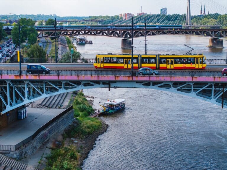 1 maja wystartuje kolejny, 16. już sezon Warszawskich Linii Turystycznych. Na stołeczne ulice wyjadą zabytkowe tramwaje i autobusy. Pełną parą ruszy kolejka wąskotorowa, na Wisłę wypłyną uwielbiane przez warszawiaków i turystów promy oraz statek wycieczkowy do Serocka. Będzie też niespodzianka – 3 maja zorganizowany zostanie plenerowy seans na plaży Poniatówka. Rozkład jazdy: Sezon 2025 Warszawskie Linie Turystyczne od lat cieszą się coraz ogromną popularnością i zainteresowaniem zarówno warszawiaków, jak i gości odwiedzających stolicę. A wszystko zaczęło się w 2009 roku, kiedy to zadebiutowały promy, statek do Serocka oraz linia tramwajowa obsługiwana zabytkowymi wagonami. W następnych latach dołączyły do nich – pamiętające dawną Warszawę – autobusy i kolej wąskotorowa. W tym roku, miłośników WLT czeka kilka zmian i nowinek. – Na początek zapraszamy do kina na plaży. W sobotę, 3 maja, o godz. 20:30, spotkajmy się na Poniatówce (nadwiślańska plaża po praskiej stronie, między mostem Józefa Poniatowskiego, a Świętokrzyskim). Przygotowaliśmy prawdziwą kinową ucztę dla wielbicieli kultowych, polskich filmów. W repertuarze „Nie lubię poniedziałków” i „Brunet wieczorową porą” (start seansu o godz. 22:10). Zapewniamy wygodne leżaki, popcornowy poczęstunek oraz wspaniały widok na rzekę i stolicę. Wstęp na wydarzenie jest wolny – powiedziała Katarzyna Strzegowska, dyrektorka Zarządu Transportu Miejskiego w Warszawie. Linia tramwajowa 36  W nowym sezonie na torach zobaczymy zabytkową i kultową już „36”. Jednak z uwagi na zaplanowane remonty, zmieni się trasa, którą będzie podążać. I tak, od 1 do 25 maja, tramwaje 36 pojadą jak co roku trasą: PL. NARUTOWICZA – Filtrowa – Nowowiejska – Marszałkowska – gen. W. Andersa – A. Mickiewicza – J. Słowackiego – METRO MARYMONT. Natomiast od momentu zamknięcia torowiska na ulicach Grójeckiej i Marszałkowskiej (Tramwaje Warszawskie zaplanowały tam modernizacje), czyli w okresie od 31 maja do 21 września, tramwaje pojadą przez al. Jana Pawła II i dalej ulicami: Prostą, M. Kasprzaka i Wolską do Cmentarza Wolskiego. Wrócą przez Wolską i Skierniewicką.  Od 1 maja do 22 czerwca tramwaje linii 36 będą kursowały w dni wolne od pracy, a od 26 czerwca aż do 21 września już codziennie. Dodatkowe dni kursowania zaplanowano na 1 maja i 19 czerwca.  Na linii 36 będzie można spotkać doskonale znane warszawiankom i warszawiakom tramwaje 13N – tzw. „parówki”, 105Na – nazywane „akwariami” oraz wyjątkowy egzemplarz 102N – ten tramwaj został sprowadzony do Warszawy z Poznania w 2004 roku. Wagony 13N to najbardziej warszawskie ze stołecznych tramwajów – stały się jednym z symboli stolicy. Widać je w wielu polskich filmach i serialach. Zostały wyprodukowane tylko z myślą o Warszawie, w chorzowskiej fabryce Konstal. Powstało ich aż 840.  Zabytkowa linia T  Na torach nie zabraknie także tramwajów linii T, które wyjeżdżać będą w wakacyjne soboty i niedziele, od 28 czerwca do 31 sierpnia – oraz dodatkowo 15 sierpnia – w godzinach 12:00-18:00 (co 45 minut). Obsługiwane będą najstarszymi wagonami z kolekcji Tramwajów Warszawskich.  „Tetka” będzie jeździła trasą z Kawęczyńskiej na Koło, a w wybranych kursach pojedzie dalej jednotorową linią przez piękne, zielone tereny na Boernerowo.  Linia autobusowa 100  Przejazd niskopodłogowymi autobusami z przełomu wieków: Jelczem, neoplanem, MAN-em i solarisem, to dla niektórych pasażerów wręcz podróż sentymentalna – były to przecież autobusy ich młodości.  Dodatkowo, podróż „setką” to świetna opcja na zwiedzanie Warszawy – po obu stronach Wisły. A to ze względu na zaplanowaną trasę: DW. CENTRALNY – E. Plater – Świętokrzyska – Prosta – Towarowa – Okopowa – M. Anielewicza – Świętojerska – Bonifraterska – Konwiktorska – R. Sanguszki – Wybrzeże Gdańskie – most Śląsko-Dąbrowski – al. „Solidarności” – Targowa – ks. I. Kłopotowskiego – Wybrzeże Szczecińskie – Most Świętokrzyski – Zajęcza – Topiel – L. Kruczkowskiego – Książęca – Aleje Ujazdowskie – Bagatela – pl. Unii Lubelskiej – Marszałkowska – Koszykowa – T. Chałubińskiego – DW. CENTRALNY.  Wycieczkę autobusem linii 100 można połączyć ze spacerem po atrakcyjnych zakątkach Warszawy. Można nim dojechać m.in. na Stare Miasto, do Parku Praskiego i ZOO, w Aleje Ujazdowskie, czy do Łazienek Królewskich.  W autobusach i tramwajach Warszawskich Linii Turystycznych obowiązują wszystkie bilety z taryfy ZTM. W przypadku pojazdów bez kasowników, bilety są kasowane przez konduktorów – członków Klubu Miłośników Komunikacji Miejskiej. Na biletach jednorazowych przesiadkowych oraz czasowych konduktorzy umieszczają pieczątkę wraz z adnotacją o dacie i godzinie rozpoczęcia przejazdu.  A może przeprawa promem?  Na turystyczne szlaki wracają również promy. Przez Wisłę przeprawić się będzie można na drugi jej brzeg w trzech miejscach: promem W1 „Słonka” – pomiędzy Cyplem Czerniakowskim (pomost pływający) a Saską Kępą (plaża); promem W2 „Pliszka” z Mostu Poniatowskiego (nabrzeże) do Stadioun Narodowego (plaża); promem W3 „Wilga”: Podzamcze z Fontannami (pomost pływający) – ZOO (plaża).  Promy będą kursowały w dni wolne: od 1 maja do 30 czerwca, od 1 do 21 września oraz 1 maja i 19 czerwca. W wakacje, od 1 lipca do 31 sierpnia, przeprawy będą działać codziennie.  Promy „Pliszka” i „Słonka” zabierają 21, a „Wilga” 40 pasażerów oraz rowery. Przeprawa jest bezpłatna.  Statek do Serocka  Na swoich fanów tradycyjnie czeka także statek „Zefir”, który będzie wypływał z przystani na Żeraniu i kanałem oraz przez Zalew Zegrzyński dopłynie do Serocka. Trasa rejsu prowadzi fragmentem wodnego szlaku Batorego. Dodatkowo statek podpływa pod ruiny starego mostu z 1897 roku, który został wysadzony w 1915 roku przez wycofujące się wojska rosyjskie. „Zefir” zabiera na pokład 80 pasażerów. Na statku jest grill oraz bufet z ciepłymi i zimnymi napojami. W Serocku przewidziano czas na odpoczynek na lądzie (ok. 2 h), a następnie powrót do Warszawy. Podróż rozpoczyna się o godz. 9.00, a powrót do Warszawy jest planowany ok. godz. 18.00.  Statek do Serocka będzie pływał od 1 maja do 21 września w soboty, niedziele i święta oraz: 1 maja, 19 czerwca, 11 lipca, 25 lipca, 8 sierpnia oraz 22 sierpnia.  Bilety na rejs można kupić:  na stronie internetowej www.bilety24.pl – już od czwartku 24 kwietnia;  w Punkcie Obsługi Pasażerów Dworzec Wileński – w czwartki (od 24 kwietnia) w godz. 15:00-18:00 (płatność tylko gotówką).  Piaseczyńsko-Grójecka Kolej Wąskotorowa i linia autobusowa 51  Bardzo popularną atrakcją WLT jest także Piaseczyńsko-Grójecka Kolej Wąskotorowa. Jej historia zaczęła się pod koniec XIX wieku, kiedy zamożny warszawski krawiec Eugeniusz Paszkowski zamarzył o kolei z Warszawy do Piaseczna – biegnącej wzdłuż ówczesnego Traktu Aleksandryjskiego (obecnie ulica Puławska).  Zabytkowa kolejka wąskotorowa będzie wyruszała w każdą sobotę (w okresie 1 maja – 21 września) ok. godziny 14:00 ze stacji w Piasecznie. Przejeżdżać będzie przez Zalesie Dolne z zabytkową stacją z lat 30. XX wieku, Głosków, Runów i Złotokłos, by dotrzeć do Tarczyna. W drodze powrotnej zatrzyma się w Runowie, gdzie peron znajduje się tuż przy leśnej polanie. Tam pasażerowie mają czas dla siebie. Można przejść się na spacer do lasu, czy zwiedzić pobliski Złotokłos – przedwojenne letnisko, gdzie wychował się Marek Hłasko i mieszkał m.in. Mieczysław Fogg. Czas przejazdu kolejką wraz z piknikiem w Runowie to około cztery godziny. Do Piaseczna – skąd wyrusza kolejka, można dojechać zabytkową linią autobusową 51, która jest przeznaczona tylko dla pasażerów kolejki. Od tego sezonu autobus będzie odjeżdżać ok. godz. 13:00 z przystanku DS. Riviera 01, znajdującego się w pobliżu stacji metra Politechnika.  Na stację Piaseczno Miasto Wąskotorowe z Warszawy można dojechać również autobusami linii 727 do przystanku Kolejka Piaseczyńska.  Bilety na przejażdżkę kolejką są dostępne na stronie internetowej www.kolejka-piaseczno.pl. Można je także kupić w dniu wycieczki (jeżeli wcześniej nie zostaną wyprzedane online) w kasie na peronie w Piasecznie.  Szczegółowe informacje o WLT znajdują się na stronie WTP w zakładce „Warszawskie Linie Turystyczne”.