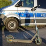 Hulajnoga elektryczna przed policyjnym busem.